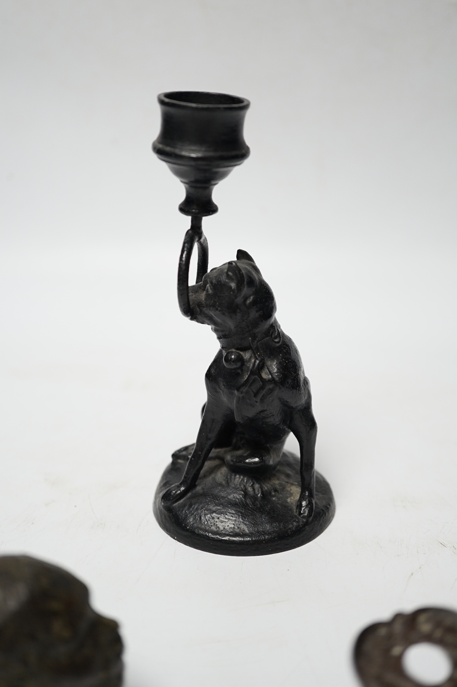 A Victorian brass hand paper clip, a small bronze tribal head and novelty dog candlestick, tallest 15cm high